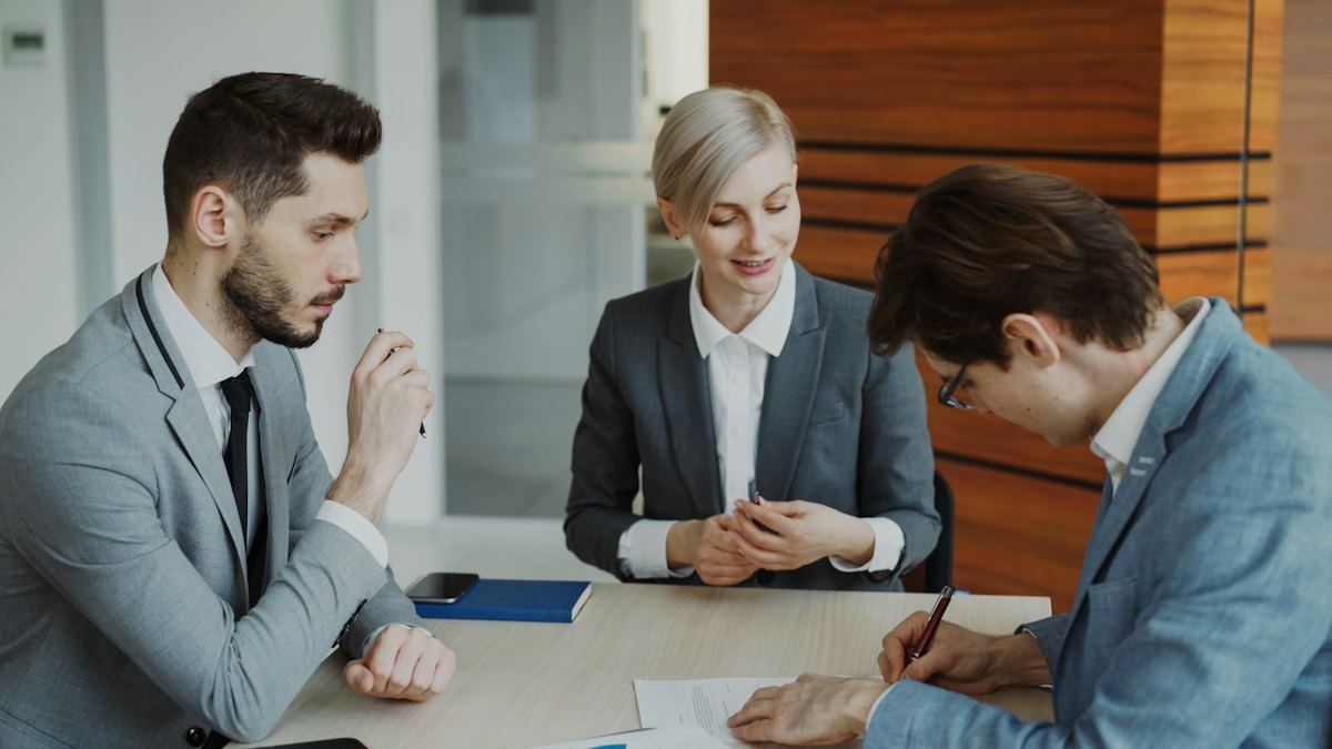 Business people signing a contract at a table