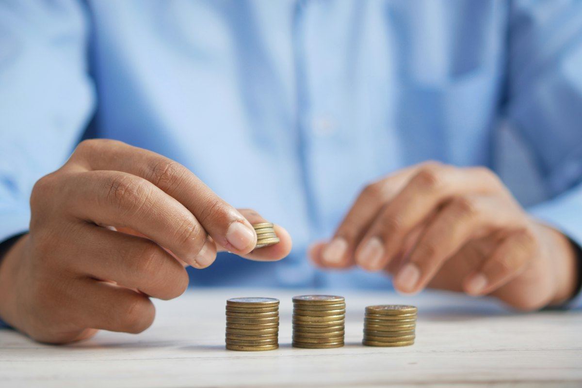 A person stacking coins on a table